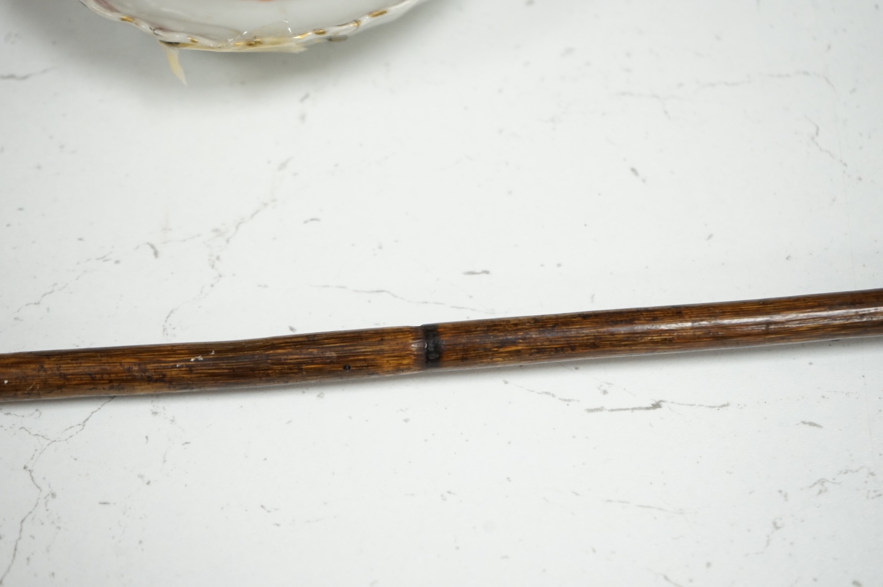 A 19th century bamboo walking stick with memento mori skull finial, the skull with articulated jaw, 84cm in length